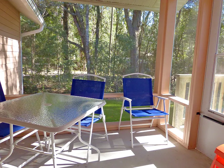 The back porch has a view of wooded and marshy areas and provides access to the grill, firepit, Gazebo and Hot Tub.