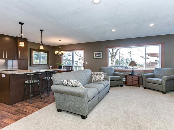 Stairs lead up to open kitchen, dining, and living room