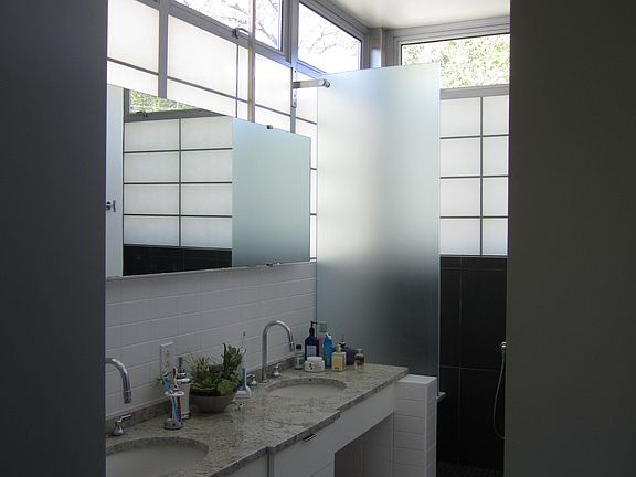 master bath with double vanity and loads of light