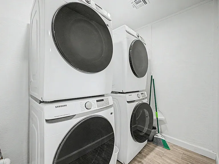 Dedicated laundry area with two stacked front-load washer/dryer sets for convenient in-home laundry access.