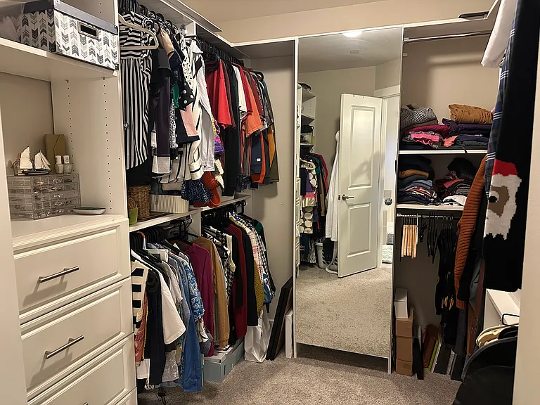 Walk in closet in primary room with long mirror