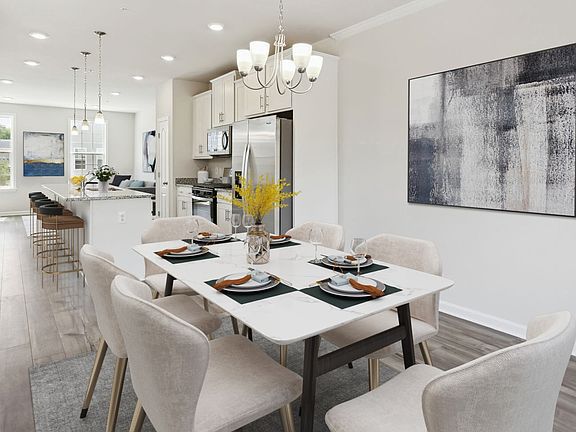 Dining room and Kitchen with LVP floors and large windows in a DRB Homes Alden Plan at the WestRidge