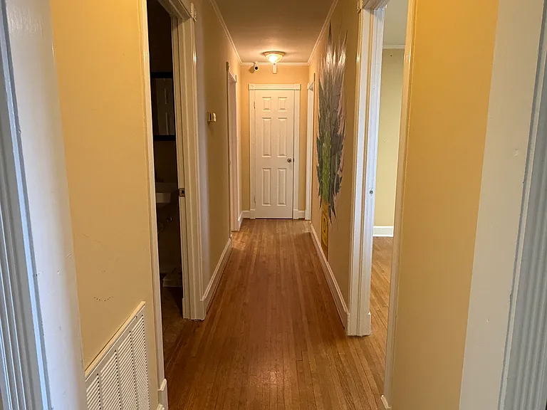 Sunlit hallway with polished hardwoods and clean, elegant lines, leading to private office spaces