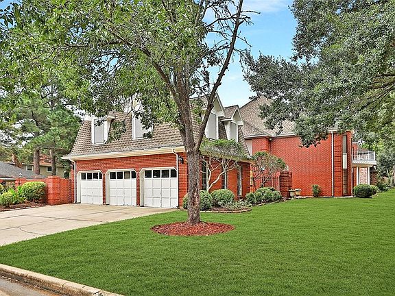 LOTS OF PARKING: In addition to the circular drive, this home boasts an oversized three car garage, with a wide driveway as well. Brick and wrought iron accent walls envelope a front courtyard and create a pretty side entrance to the backyard.