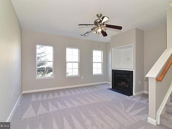 Family room has a Fireplace and ceiling fan with a view of the front private yard