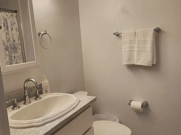 Well lit bathroom with waist-high sink and cabinet.