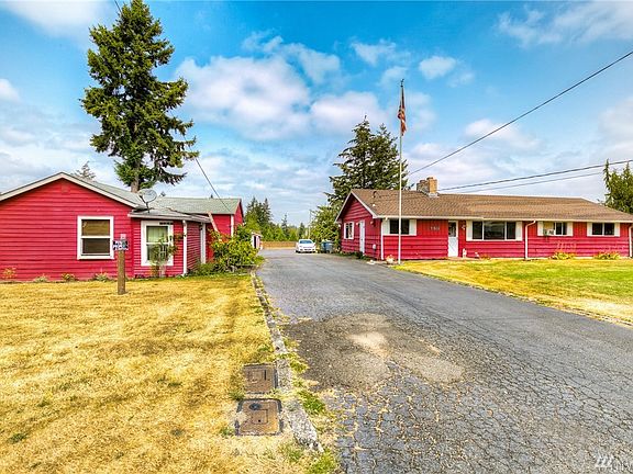 The two homes flank the wide paved driveway. 