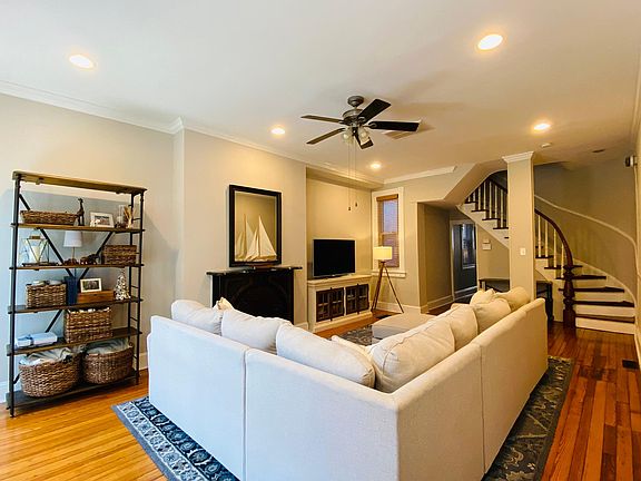 Large family room with original historical staircase and gleaming hardwood floors