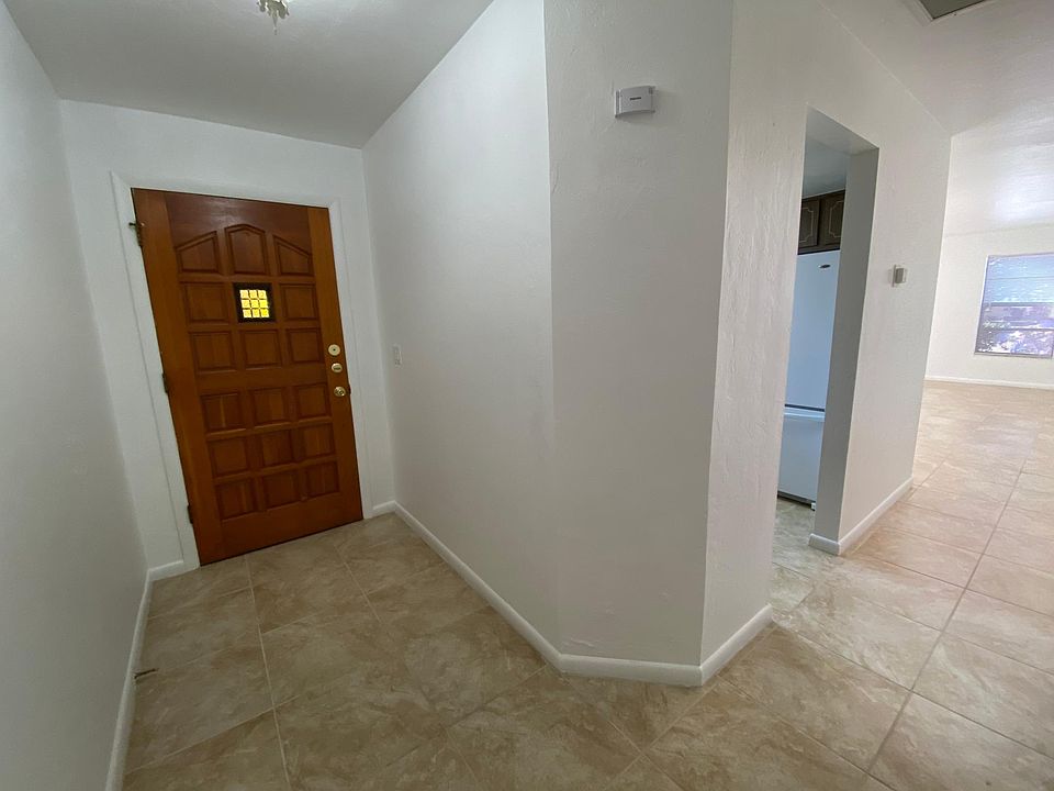 entry hallway which leads to the kitchen on the left. Across from the kitchen is the washer and dryer room. Hallway opens into the large tile living room