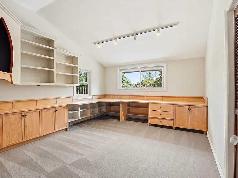 Filled with character, this upstairs bedroom features extensive built-in storage and a whimsical hidden nook sure to spark imagination and become a favorite retreat.