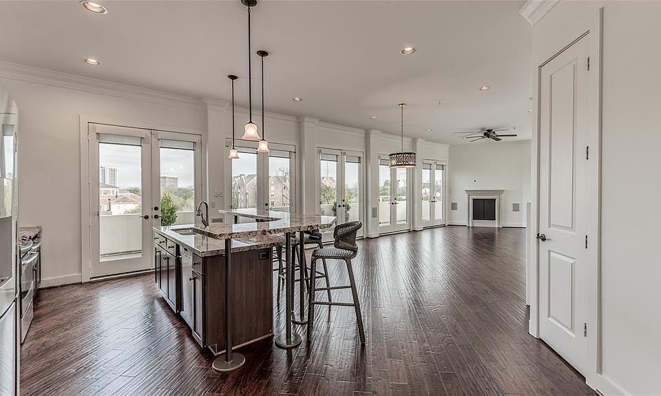 Your view as you step into the home's open Kitchen/DR/LR. 5 sets of French doors lead out to over 50' balcony with Downtown views! Engineered hardwoods laid on diagonal throughout the home. Door on right is large storage closet that could be used as 