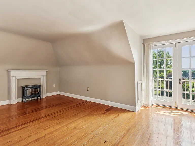 Living room with electric fireplace and French doors to the balcony