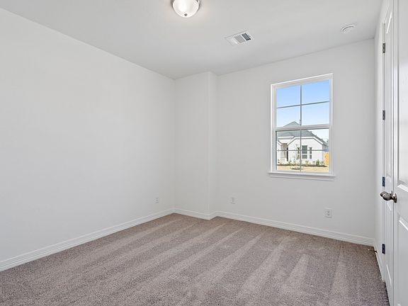 The secondary bedroom features plush carpet, fresh paint, closet, and a large window that lets in pl