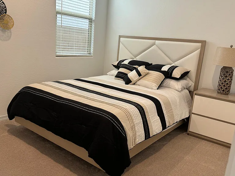 Second bedroom- queen- full dresser and smart tv on wall opposite bed