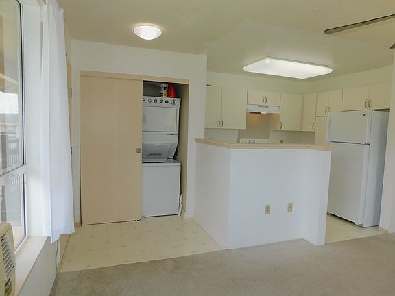 Open kitchen. Stacked washer and dryer.