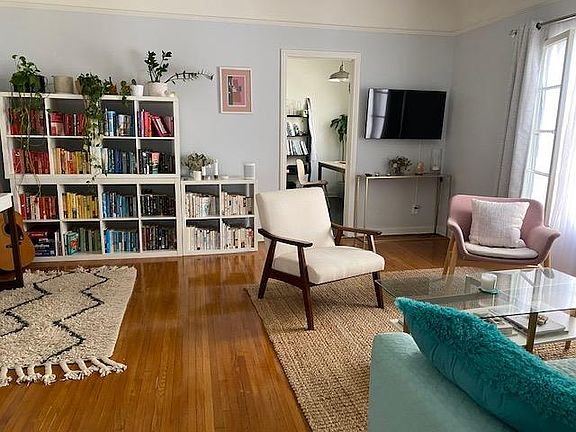 TV in right corner. Kitchen and dining area seen in doorway.