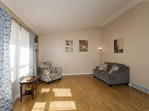 Light and bright living room with wood laminate flooring, vaulted ceiling opens