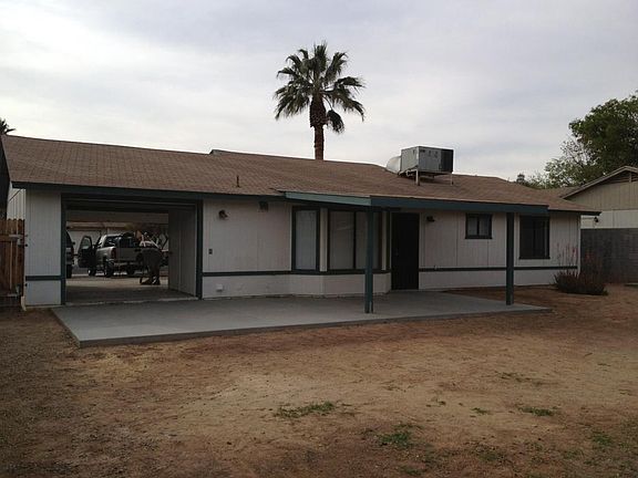BACK. COVERED PATIO AND DRIVE-THROUGH GARAGE.