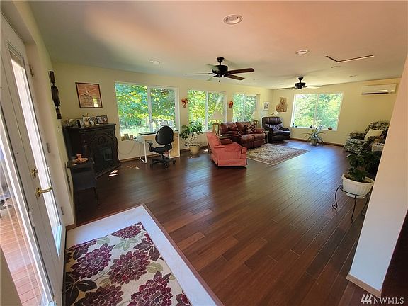 The new sunroom added 400+ sq feet (listed) to the home and is gorgeous!~ New mini split keeps the room warm in the winter and cool in the summer. Note the ceiling fans throughout the house! French doors to the right lead to the expansive deck.