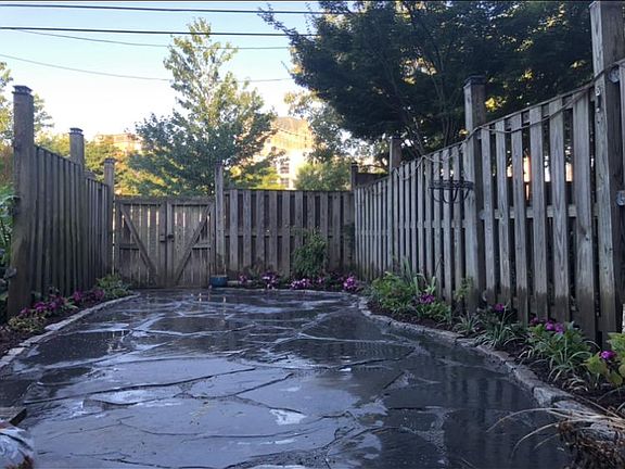 Large backyard slate patio with low maintenance flower beds