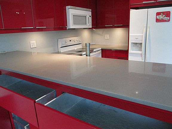 Contemporary kitchen has Silestone counters and storage on both sides of island.