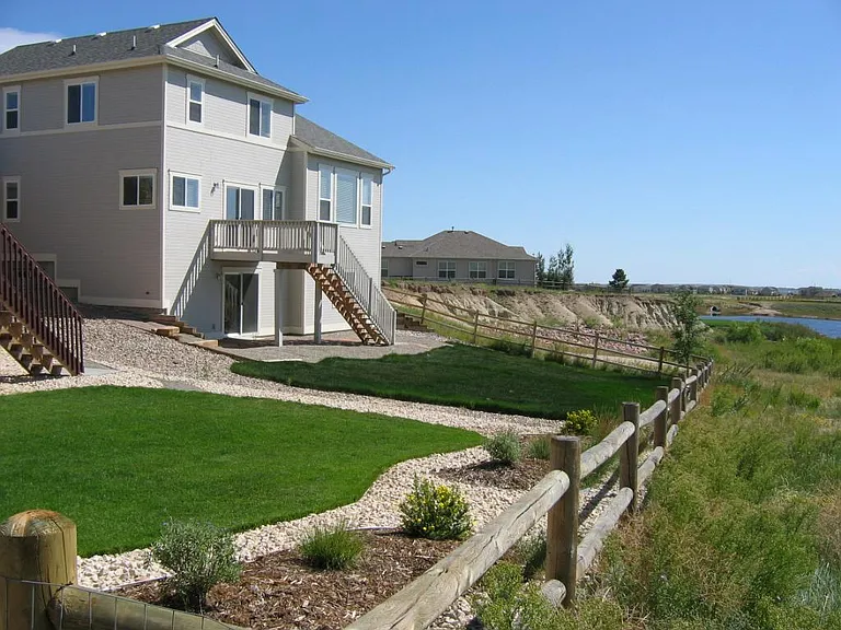 Overall view of the backyard, the neighboring house in the distance, and Eagle Lake to the far right. This shown deck has recently been replaced with a much larger Trex deck, seen in later photos.