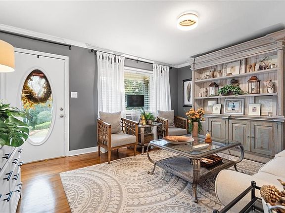 Living room featuring ornamental molding and light hardwood / wood-style flooring