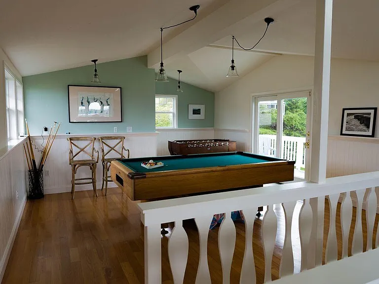 Upstairs game room with ocean views, bathroom, fireplace, deck, nook, pool table and foosball table.