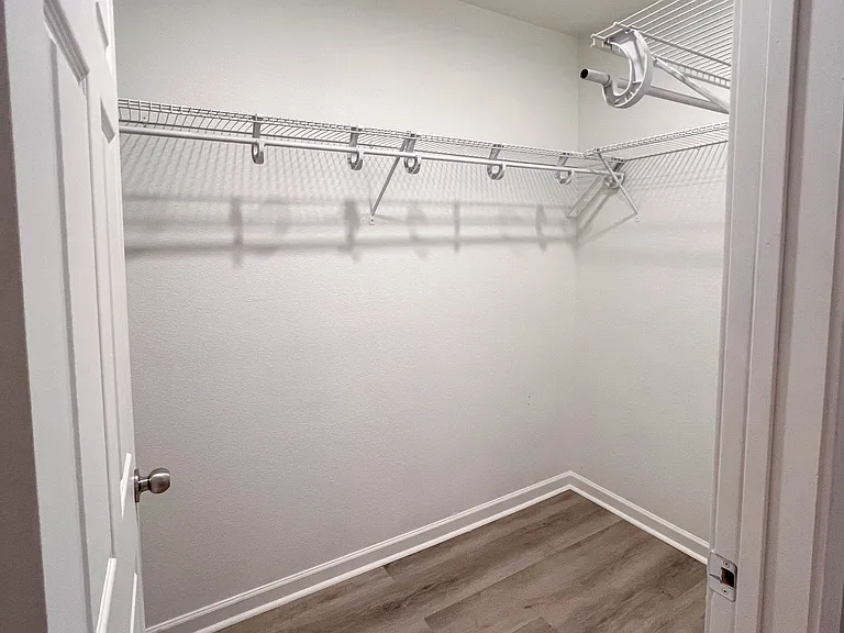 Spacious walk-in closet located directly off the primary bath with plenty of hanging and storage space.