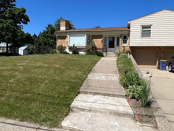 Entrance to the duplex with garage shown to the right and master bathroom window shown on the vinyl siding above the garage. Second bedroom is located next to the master bedroom above the garage.