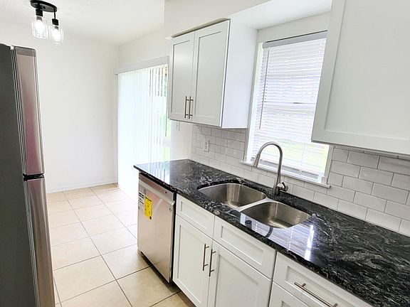 Kitchen: Double Sink, Eat-In Kitchen Nook next to Sliding Glass Doors to Patio.