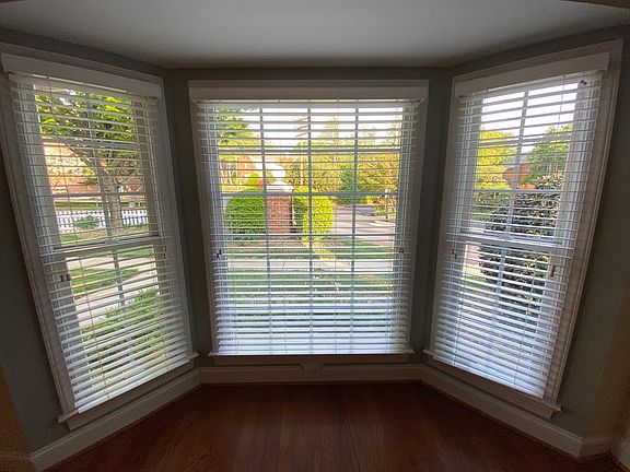 Floor to ceiling bay window in the living room onto the landscaping near the front door.