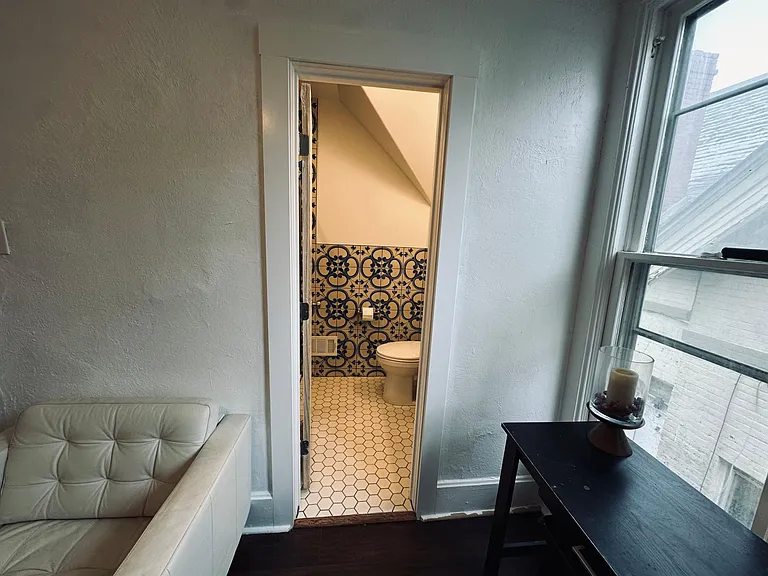 Bathroom entry from the living room view. 
Newly renovated bathroom, walk in shower with rain shower head, handheld shower head, glass sliding door. Water saving toilet, beautiful marble vanity, spanish wall tile. North facing windows.