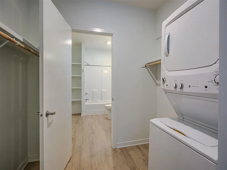 In-unit washer and dryer and bathroom entrance in a unit at The Rise.