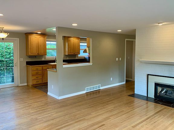 Great room with large living room space, gas fireplace, dining area, and kitchen.