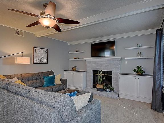 Family room with wood burning fireplace and builtins.