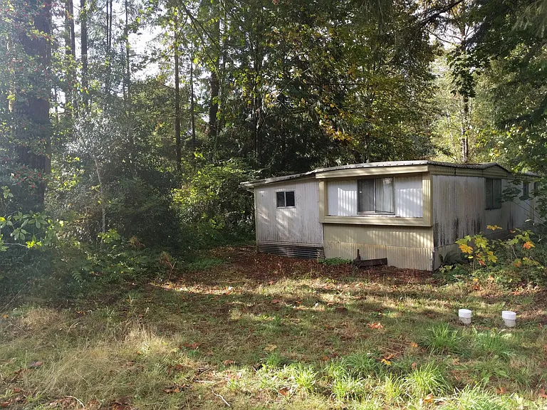 Hitch side of the trailer on the narrow end of the lot facing street (opposite of the creek) and addition