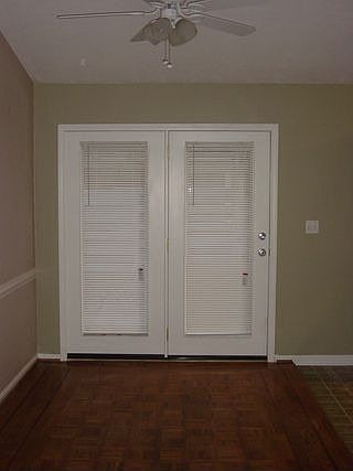 Dining area with hardwood flooring and ceiling fan. French doors lead to private patio area.