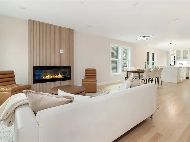 Bright, open-concept living space featuring a modern fireplace and designer lighting.