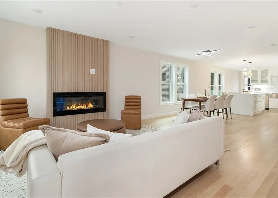 Bright, open-concept living space featuring a modern fireplace and designer lighting.