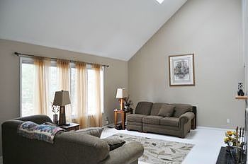 The Great room is located just off the main entrance.  It is finished with neutral colors and features a vaulted ceiling with new skylights.  The windows look our over the heavily wooded front yard.