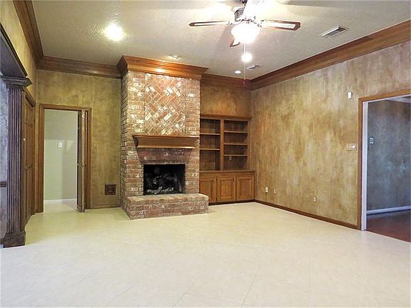 Family room with with brick surround fireplace and tile floors.