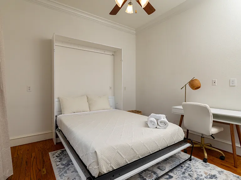 Versatile downstairs bedroom with a queen Murphy bed and workspace.