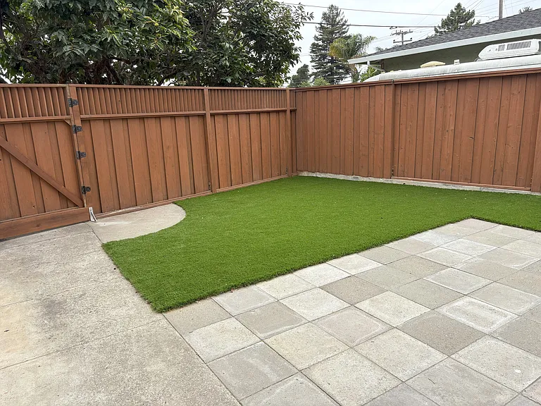 ADU includes a large yard with artificial grass and concrete-paver patio. This is the view from the entry door. Entry gate is on the left.