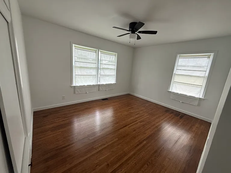 Bright bedroom featuring beautiful hardwood floors, ample natural light, and generous closet space