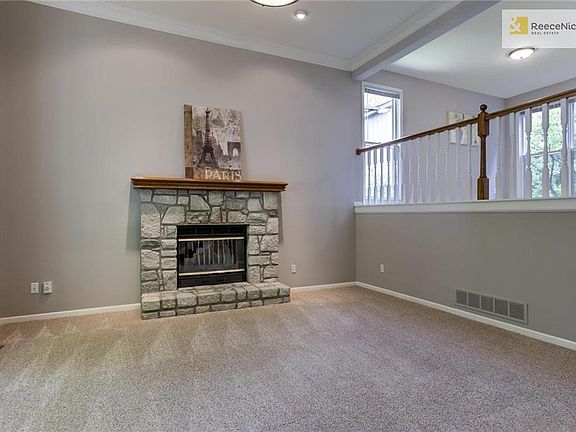Entry opens up to large great room with tall ceilings and stone fireplace.