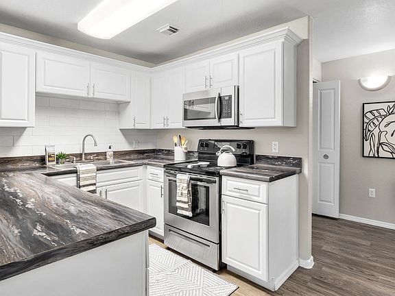 Whip up culinary masterpieces in a gleaming kitchen with abundant storage and modern appliances.