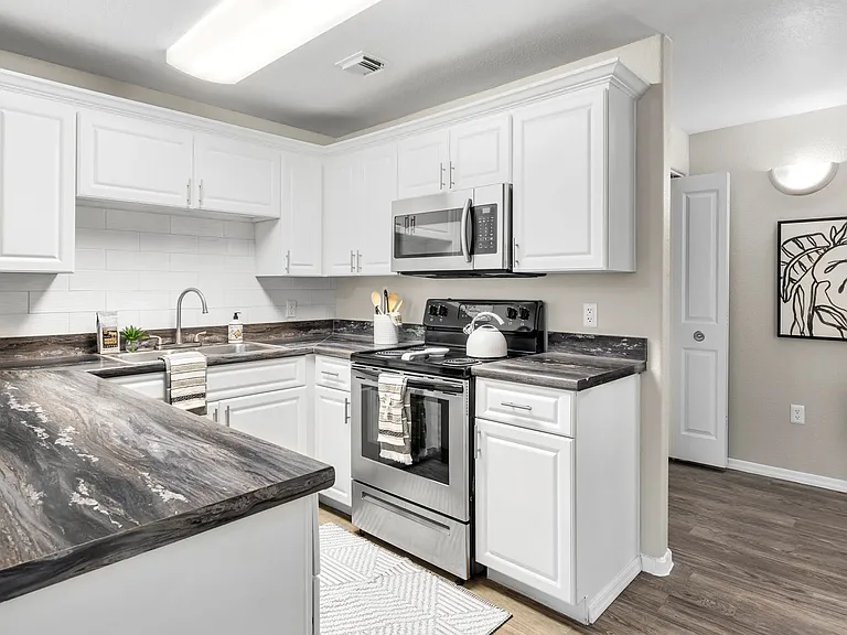 Whip up culinary masterpieces in a gleaming kitchen with abundant storage and modern appliances.