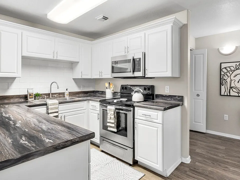 Whip up culinary masterpieces in a gleaming kitchen with abundant storage and modern appliances.