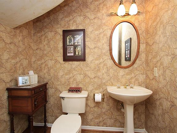 The generously sized powder room with pedestal sink is discreetly located.
